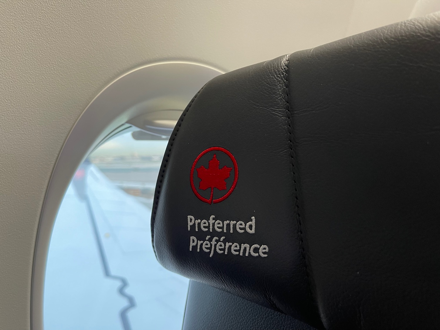 a black leather arm rest with a red logo on it