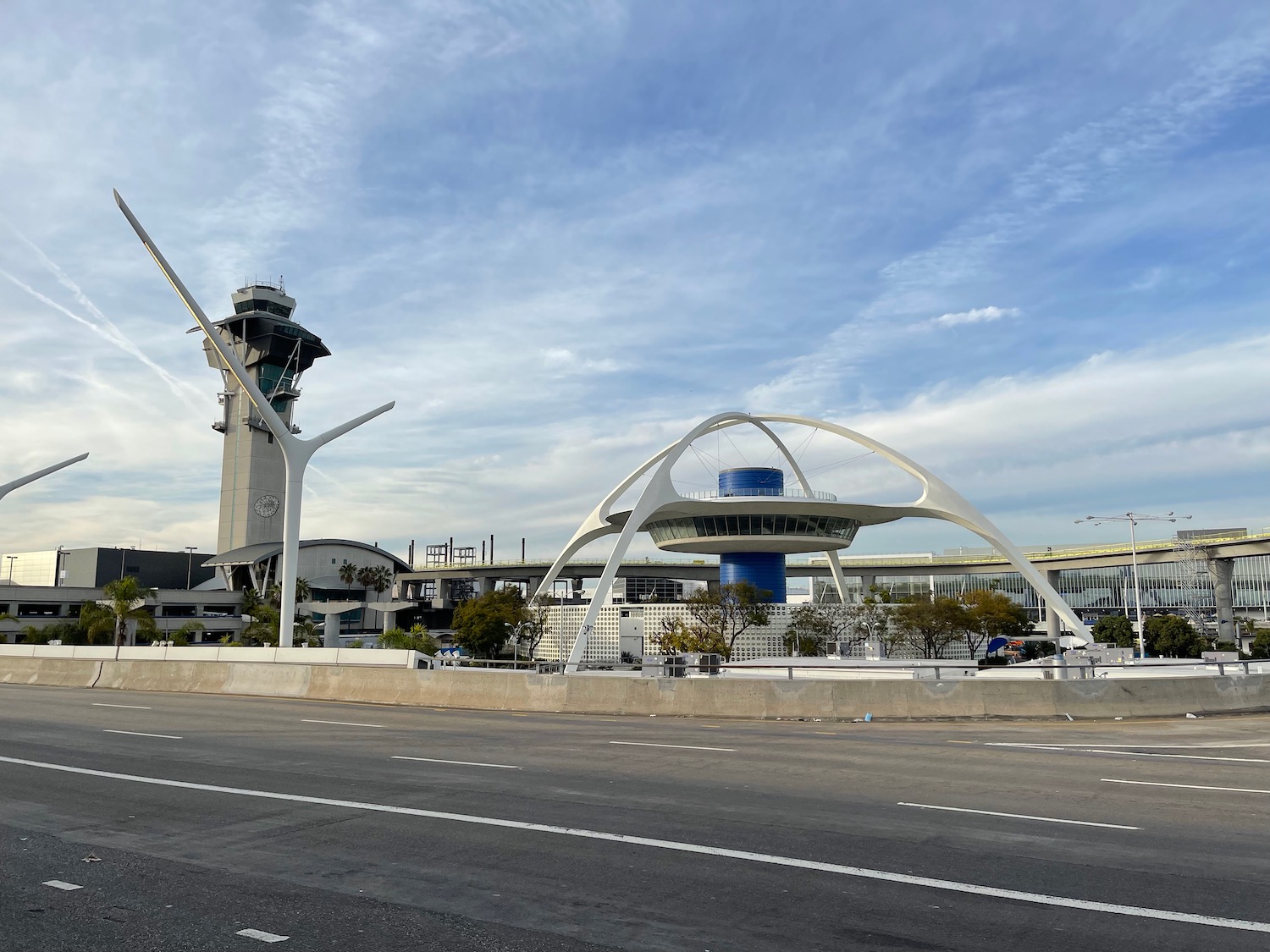 a road with Theme Building and a tower