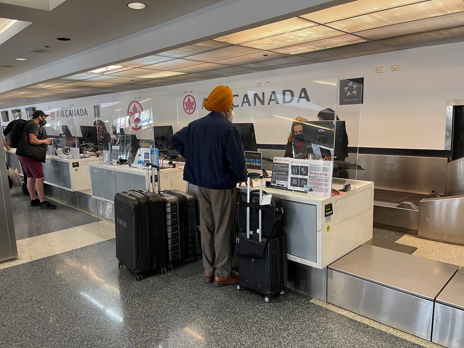 a man standing in front of a counter with luggage