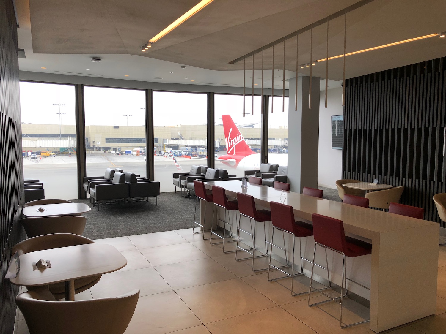 a room with tables and chairs and a plane in the background