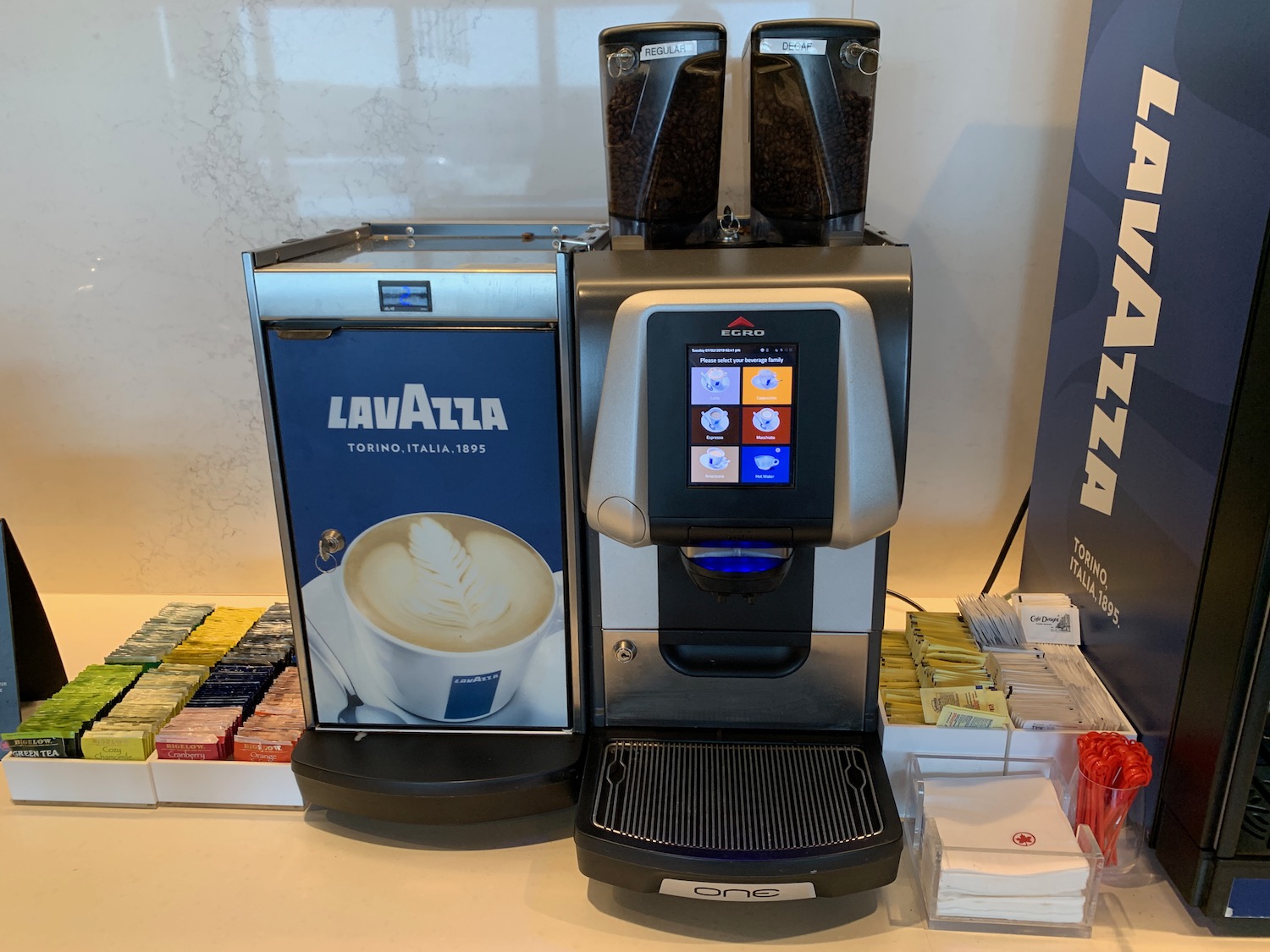 a machine with a screen and a container of coffee