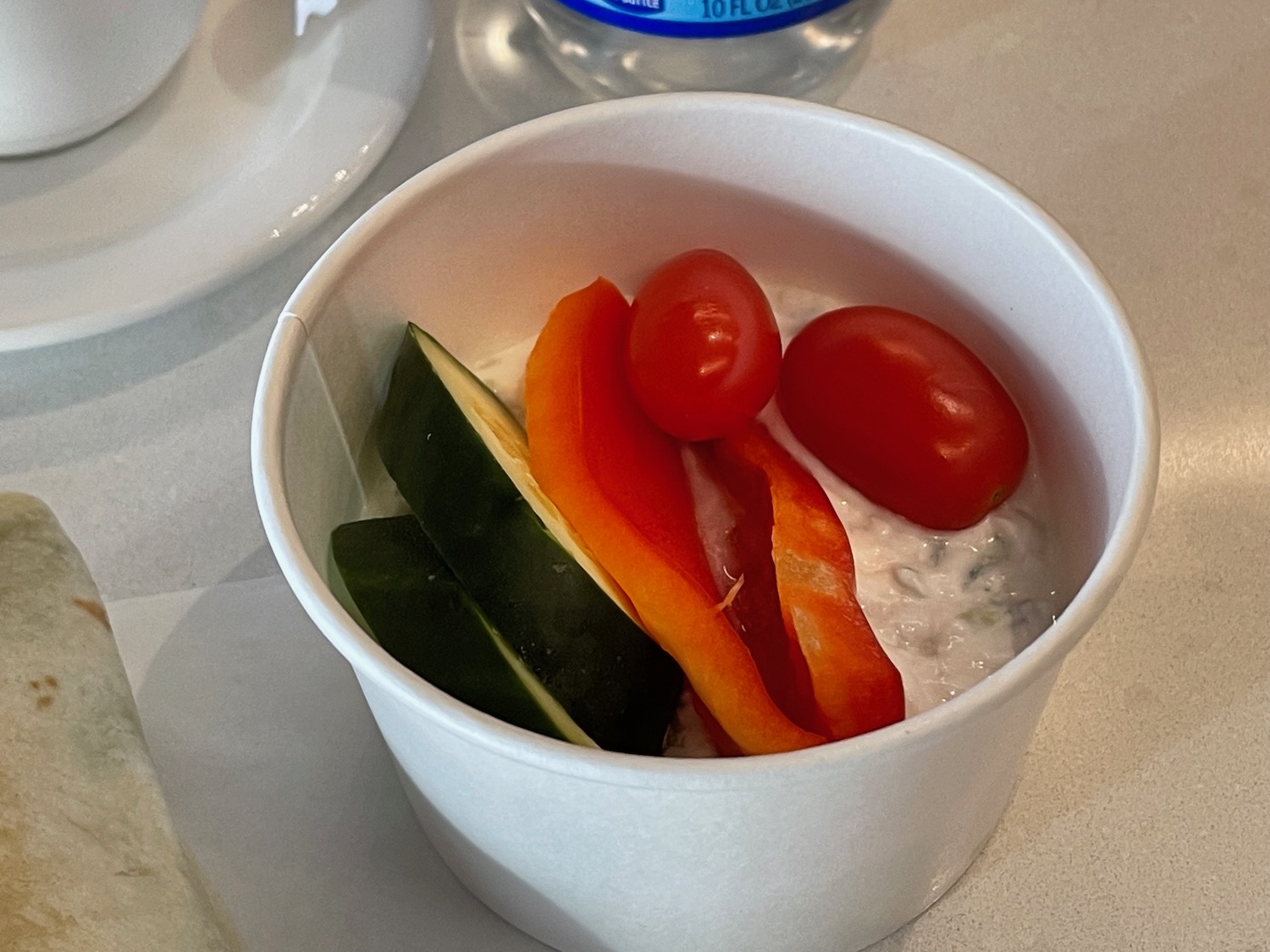 a cup of food with vegetables in it