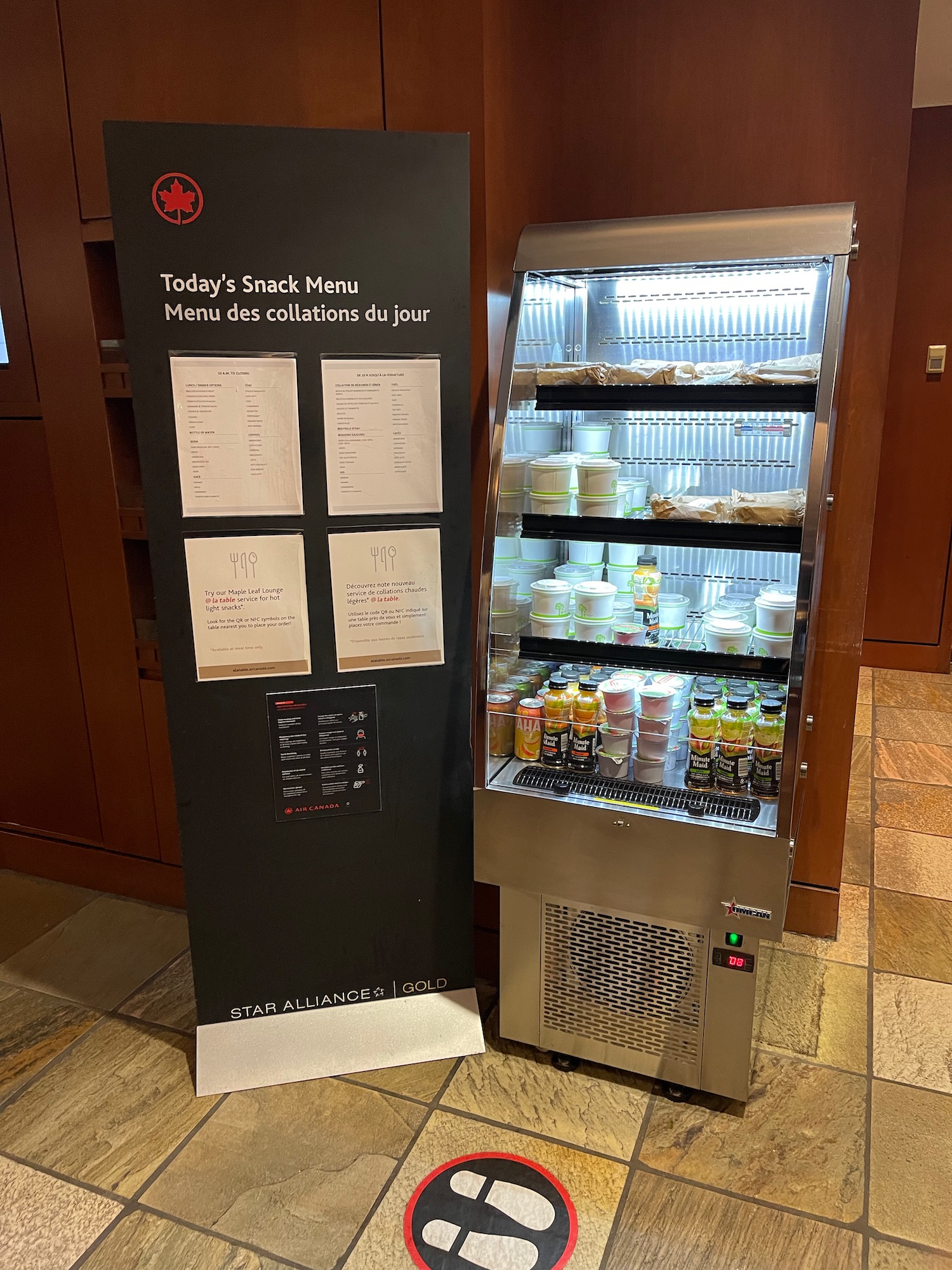 a food and drink dispenser next to a refrigerator