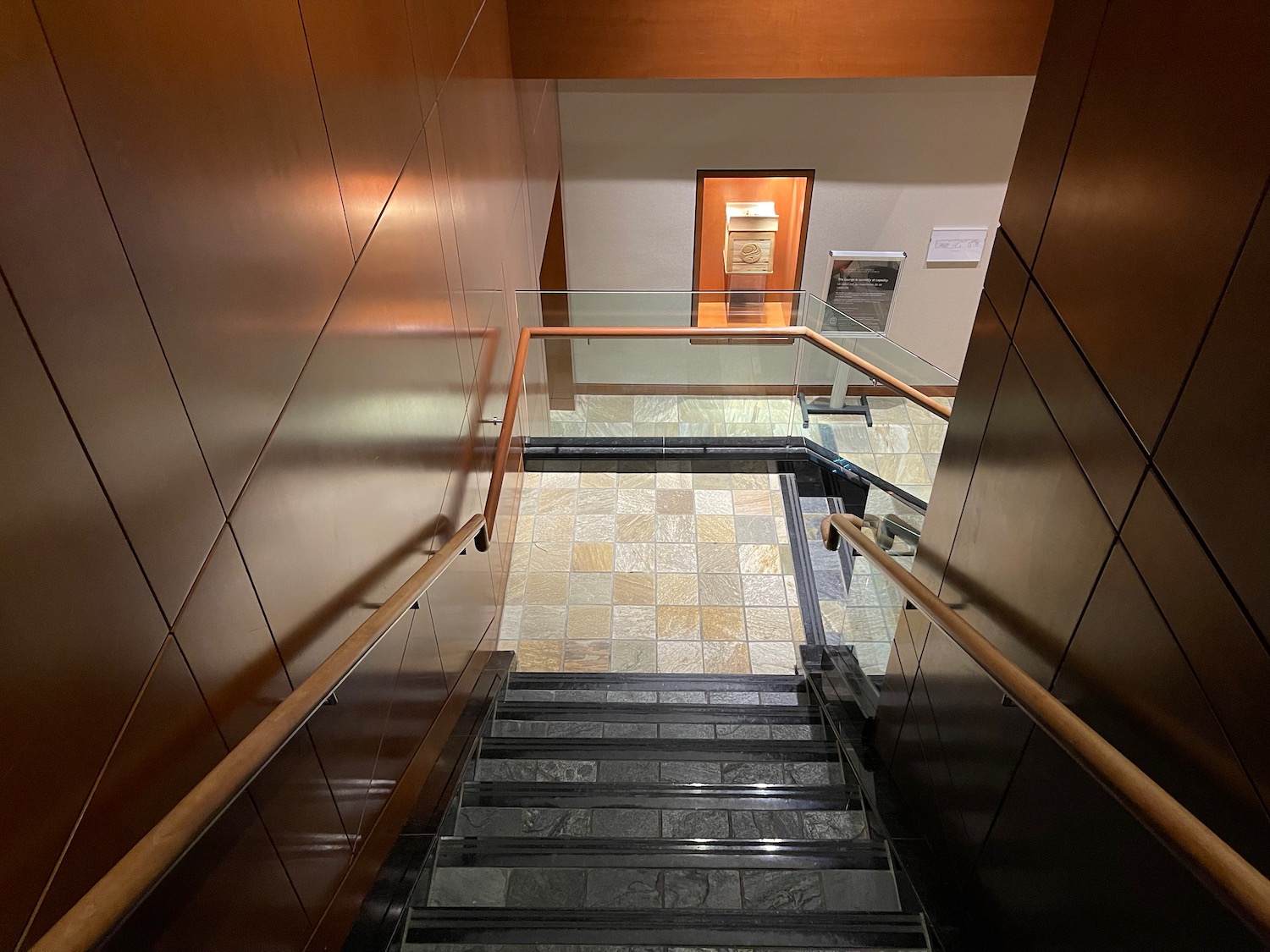 a staircase with glass railings and tile floor