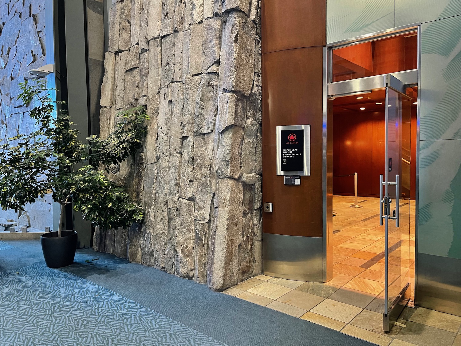 a stone wall with a glass door and a sign