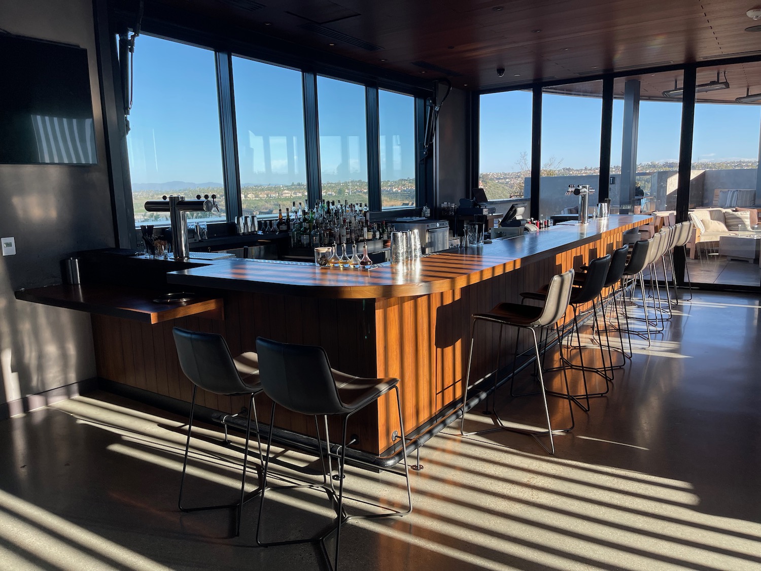 a bar with chairs and a large window