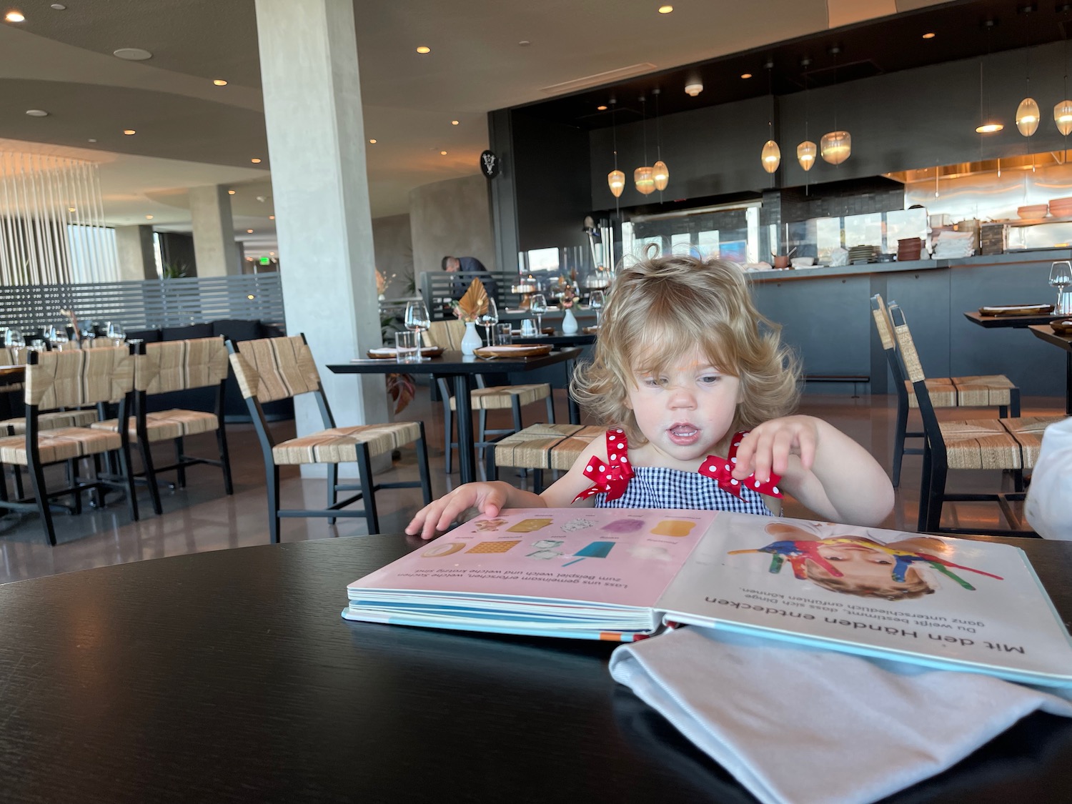 a child sitting at a table reading a book