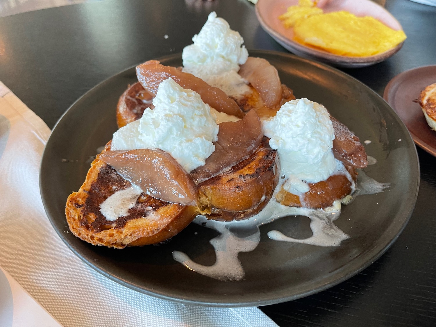 a plate of food with whipped cream and pears