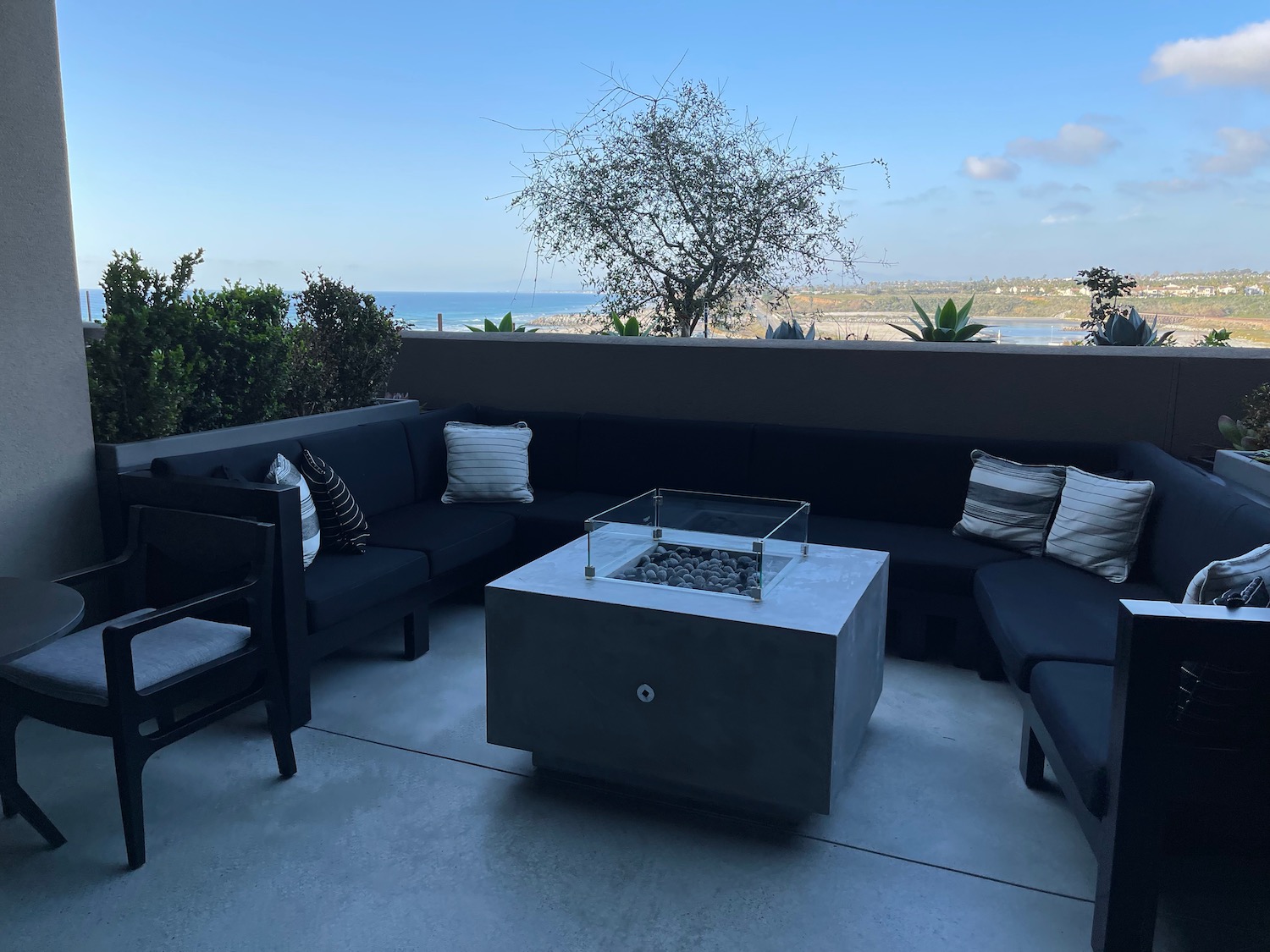 a patio with a fire pit and couches