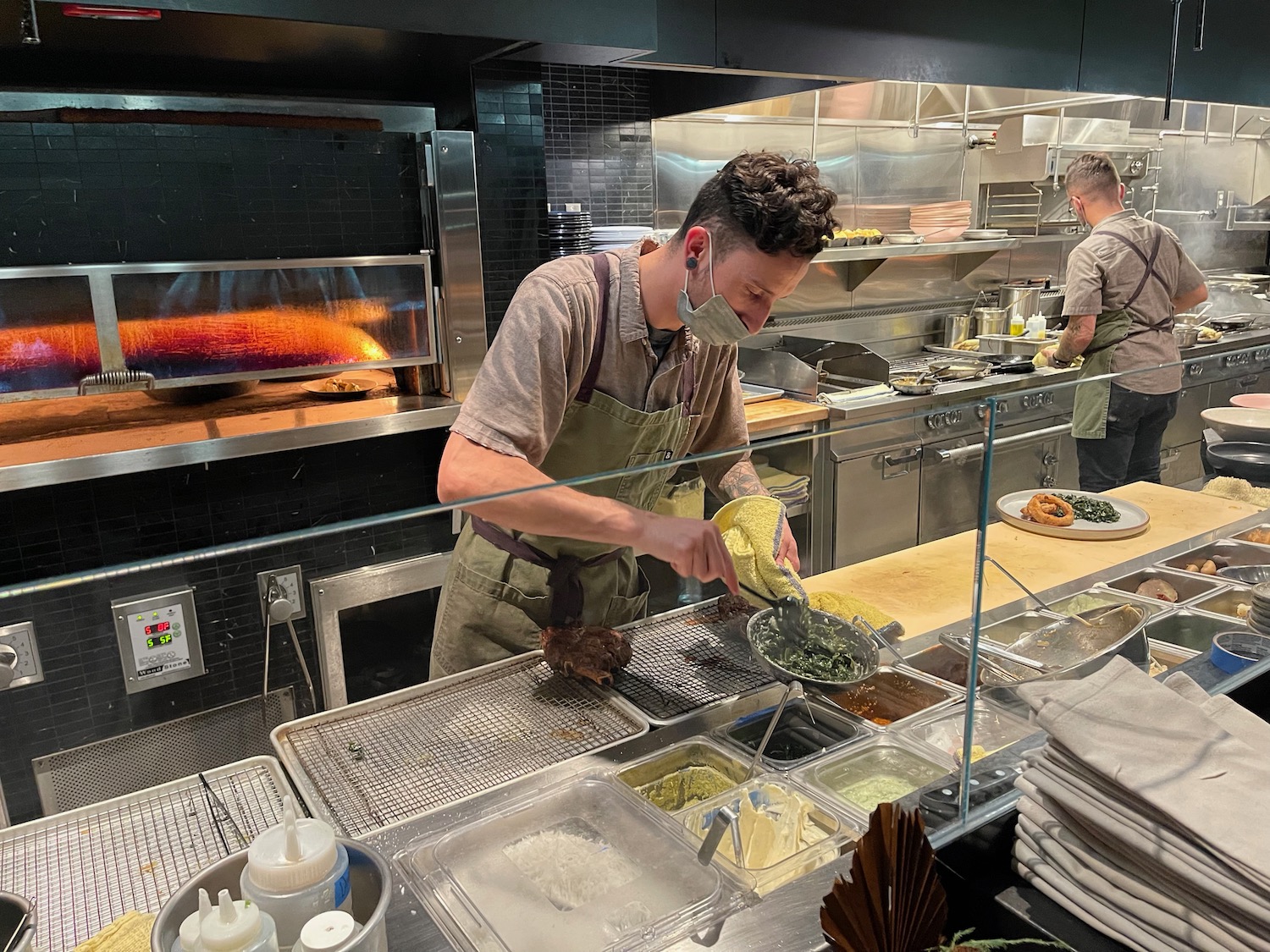 a man wearing a mask and cooking food in a kitchen