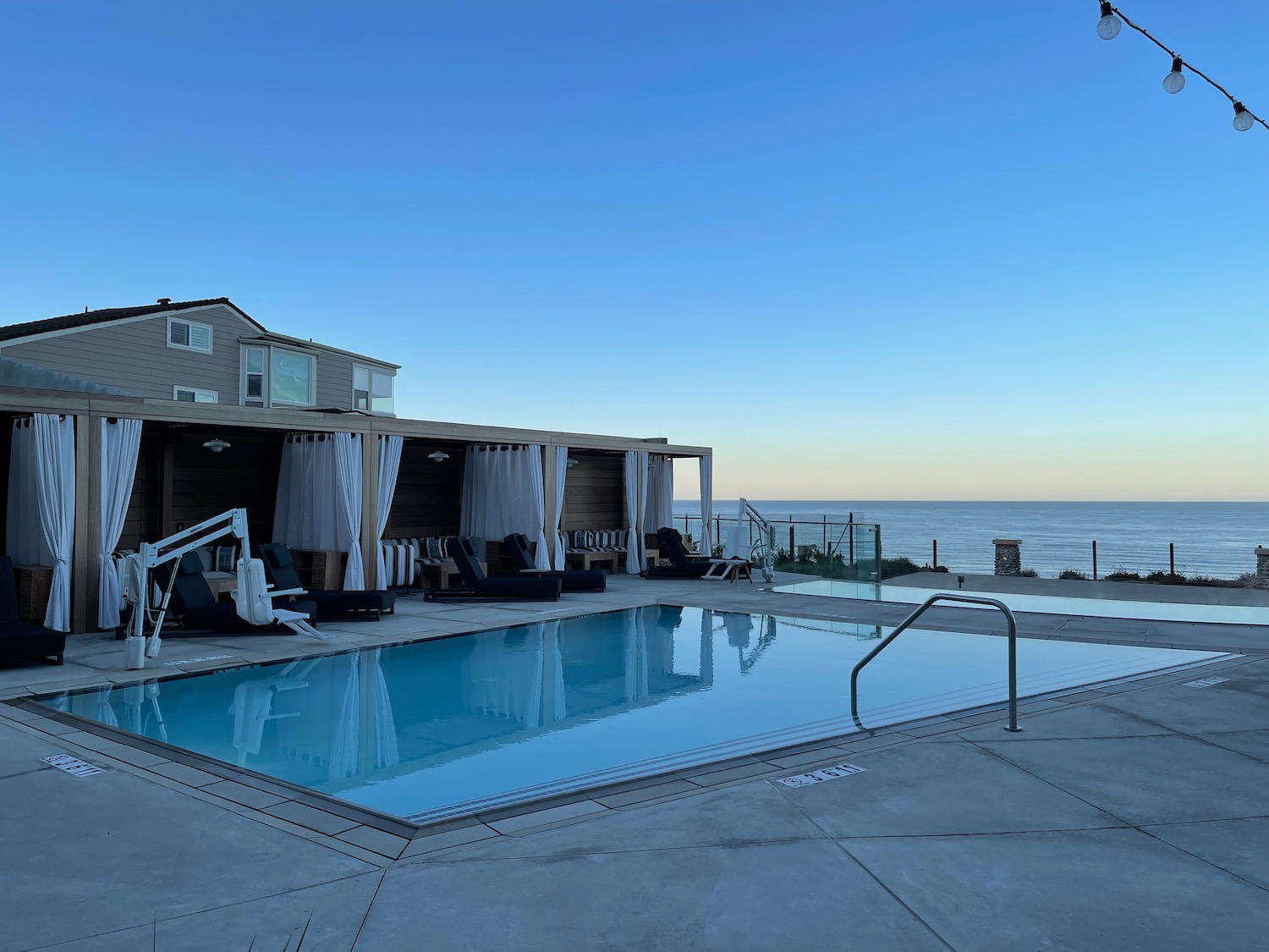 a pool with a deck and chairs on the side