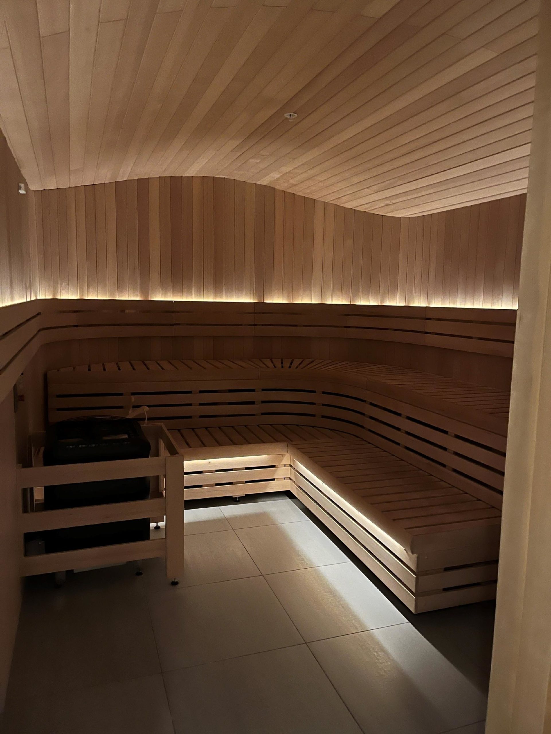 a wooden sauna with a light on the ceiling