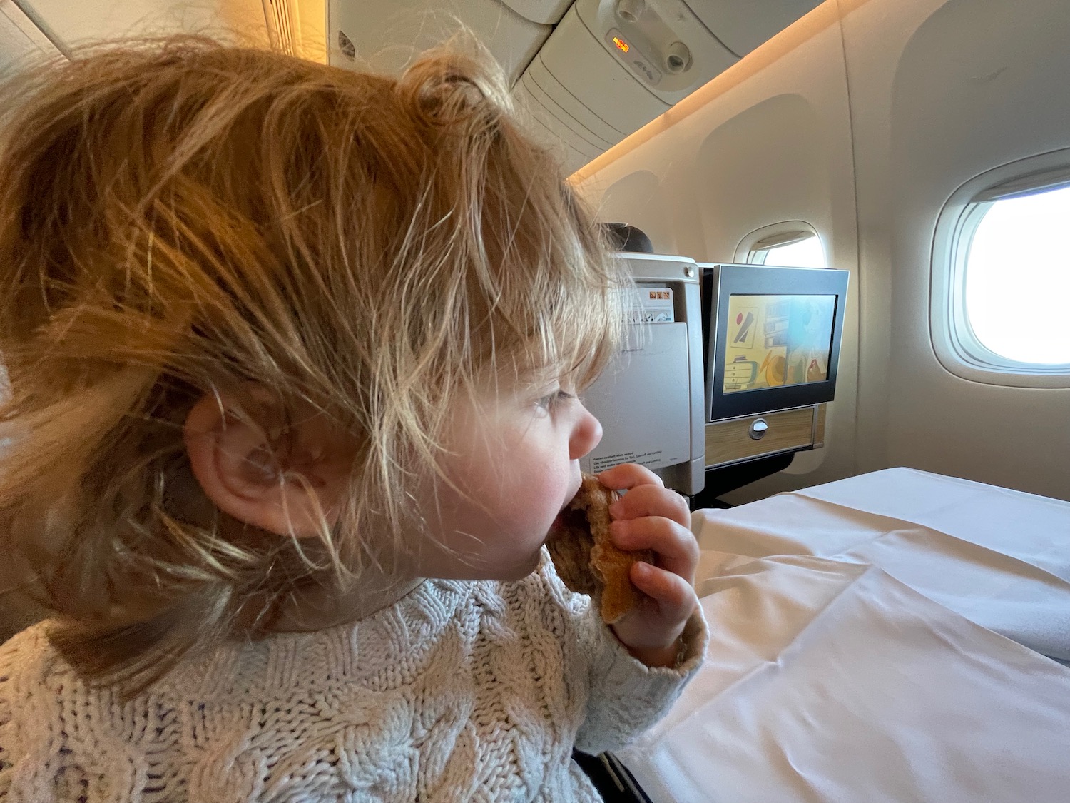 a child eating a cookie in an airplane