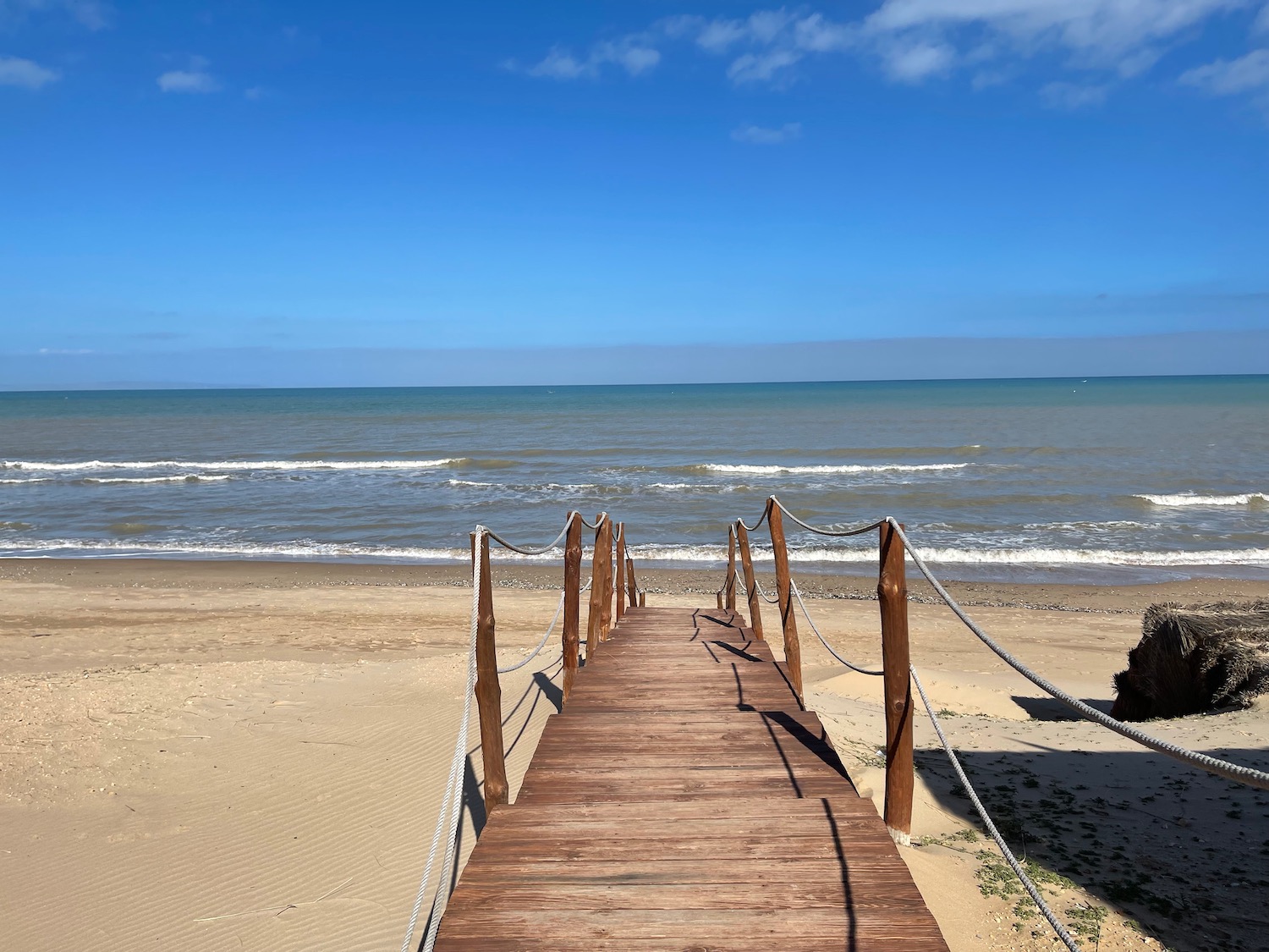 a wooden walkway leading to a beach