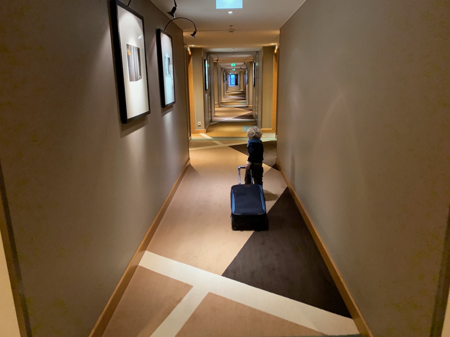 a child with a suitcase in a hallway