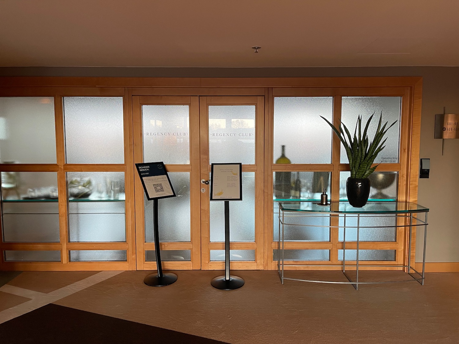 a glass doors with a plant on a glass table