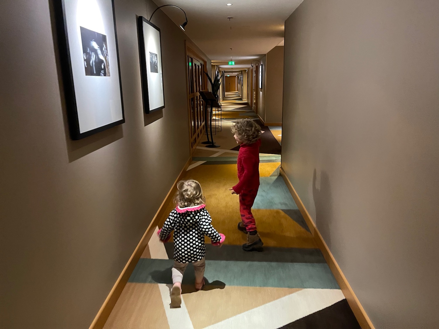 two children walking in a hallway