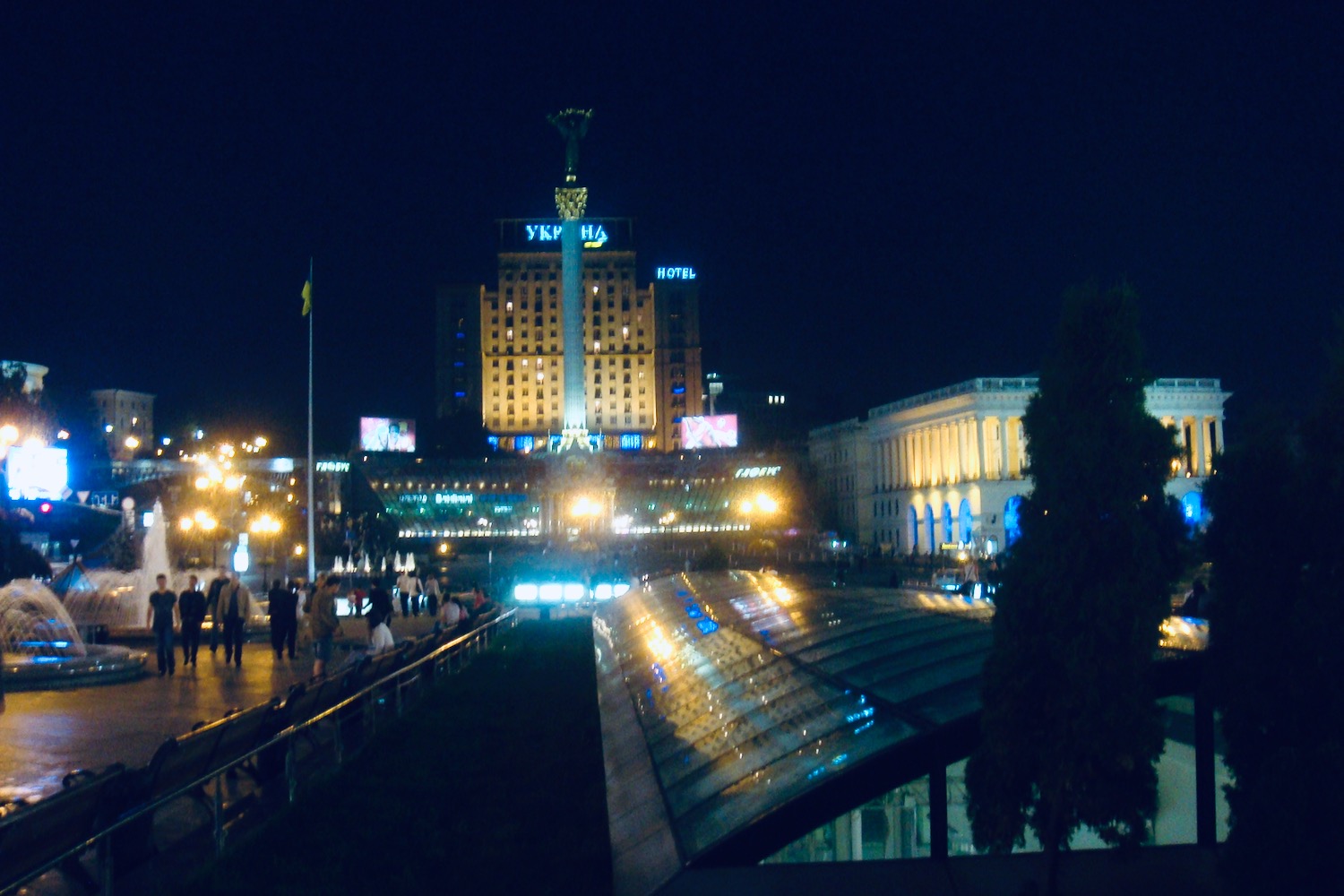 a city at night with a large building and people