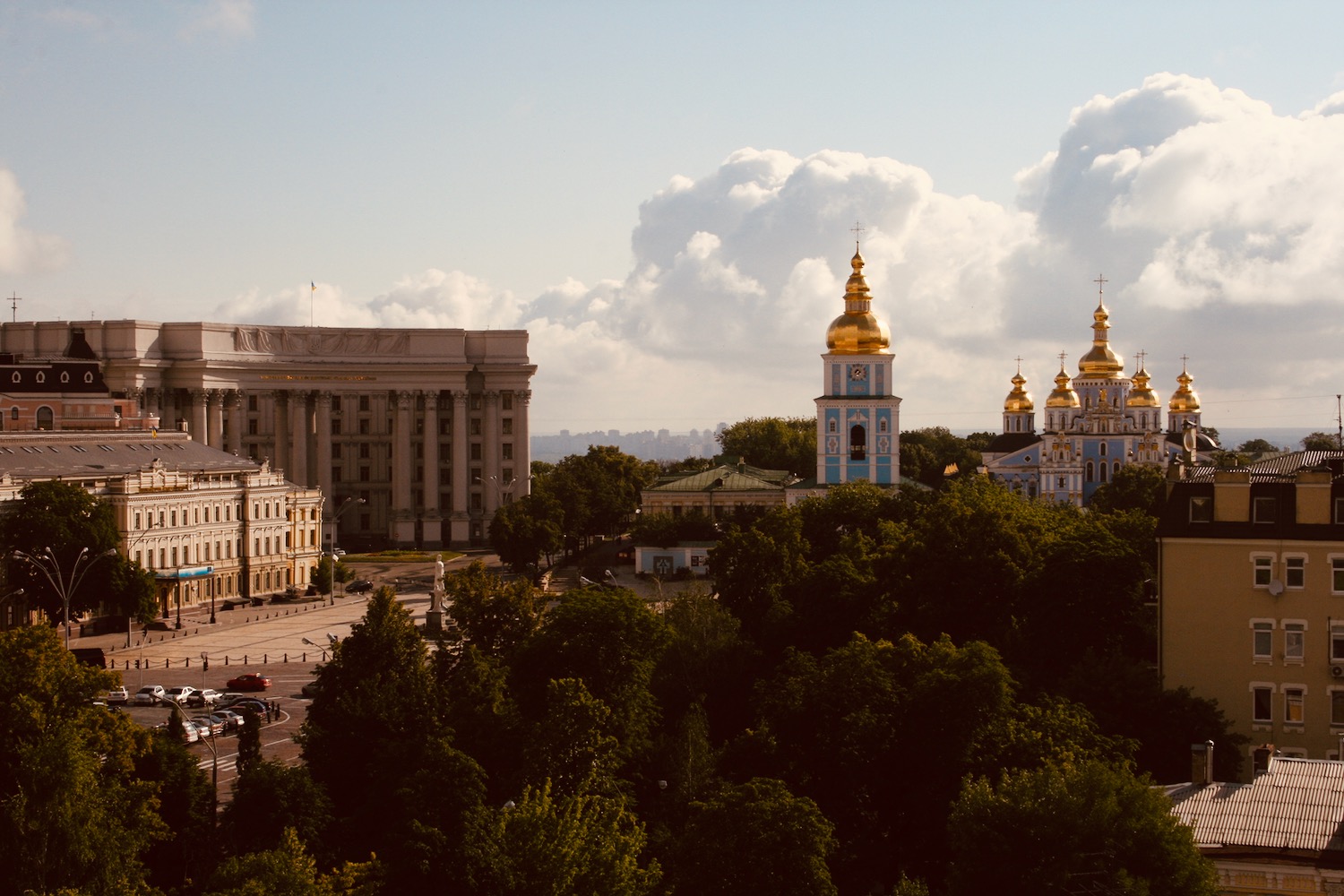 a group of buildings with gold domes and trees