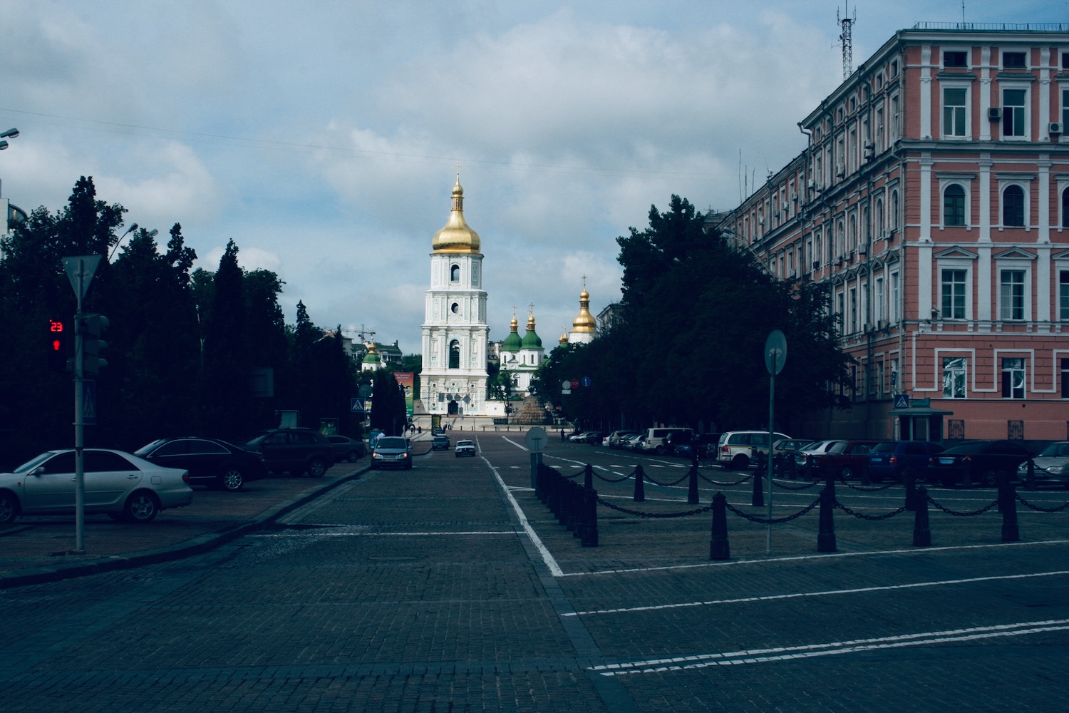 a street with cars and a building with a tower