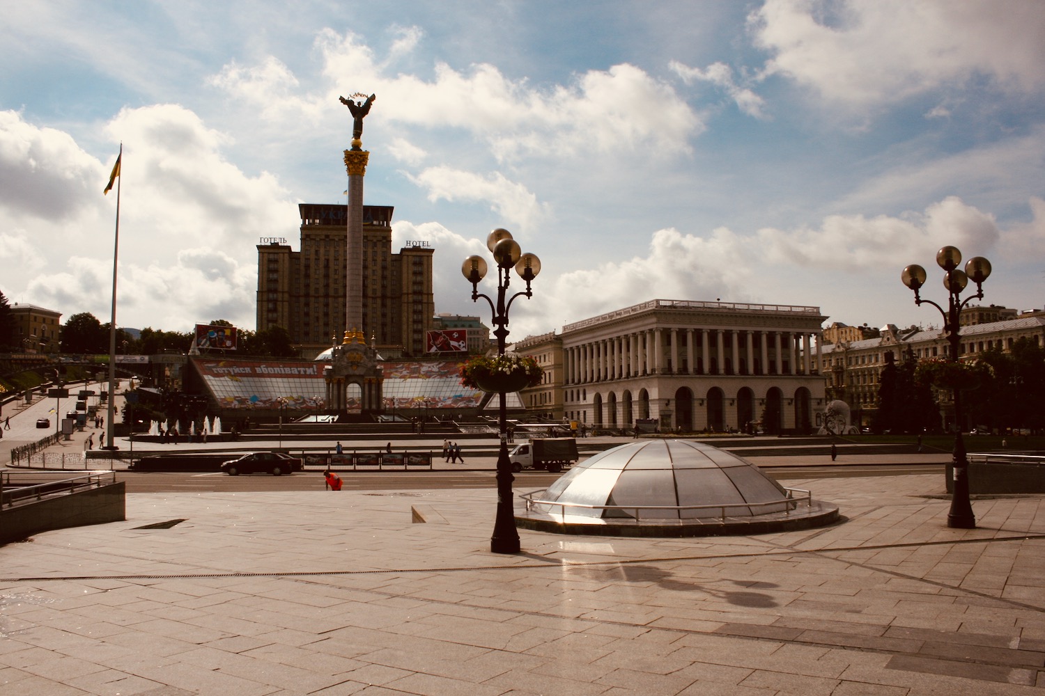 a large square with a statue and buildings in the background