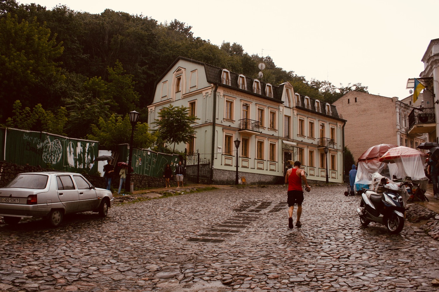 a man walking on a cobblestone road with a couple of people