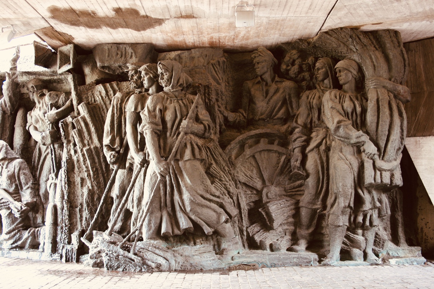 a stone sculpture of people in a tunnel