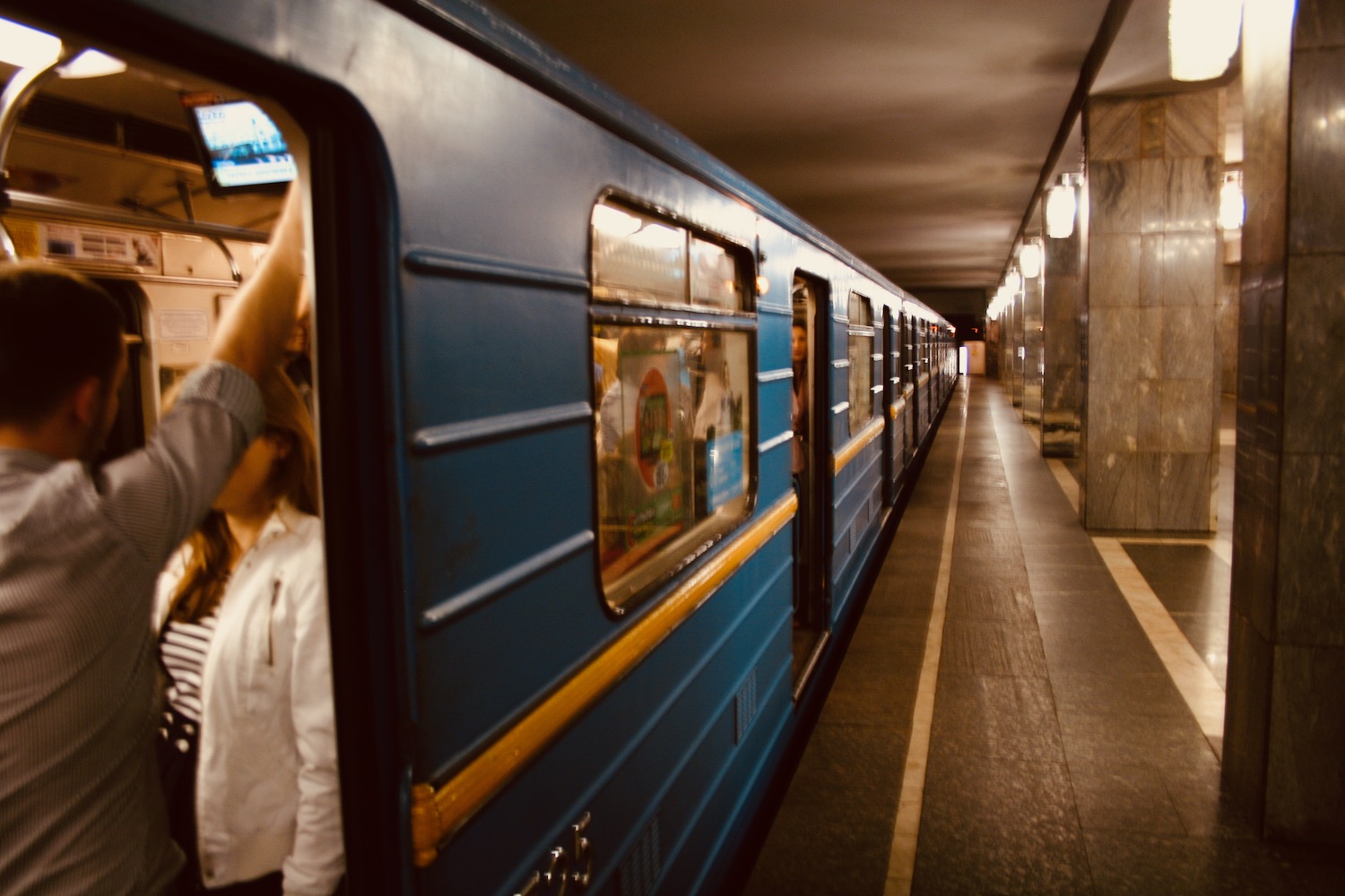 a blue train in a subway station