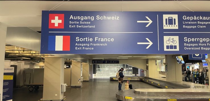 a sign with a person standing in front of a luggage carousel