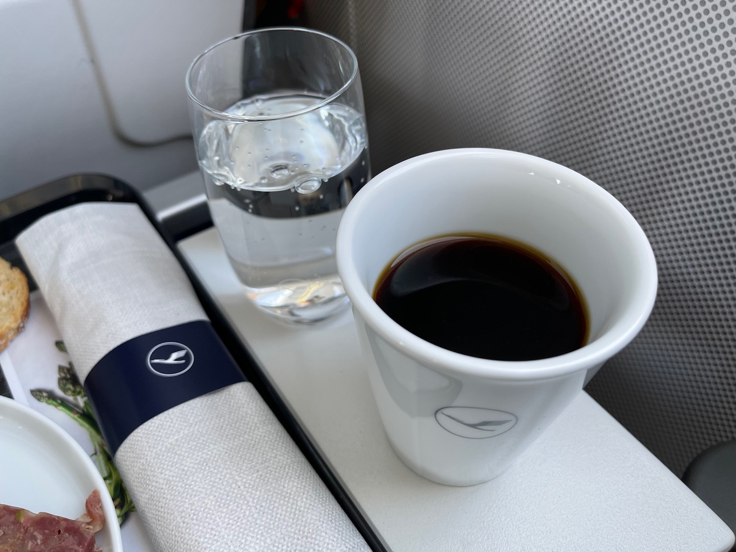 a cup of coffee and a glass of water on a tray