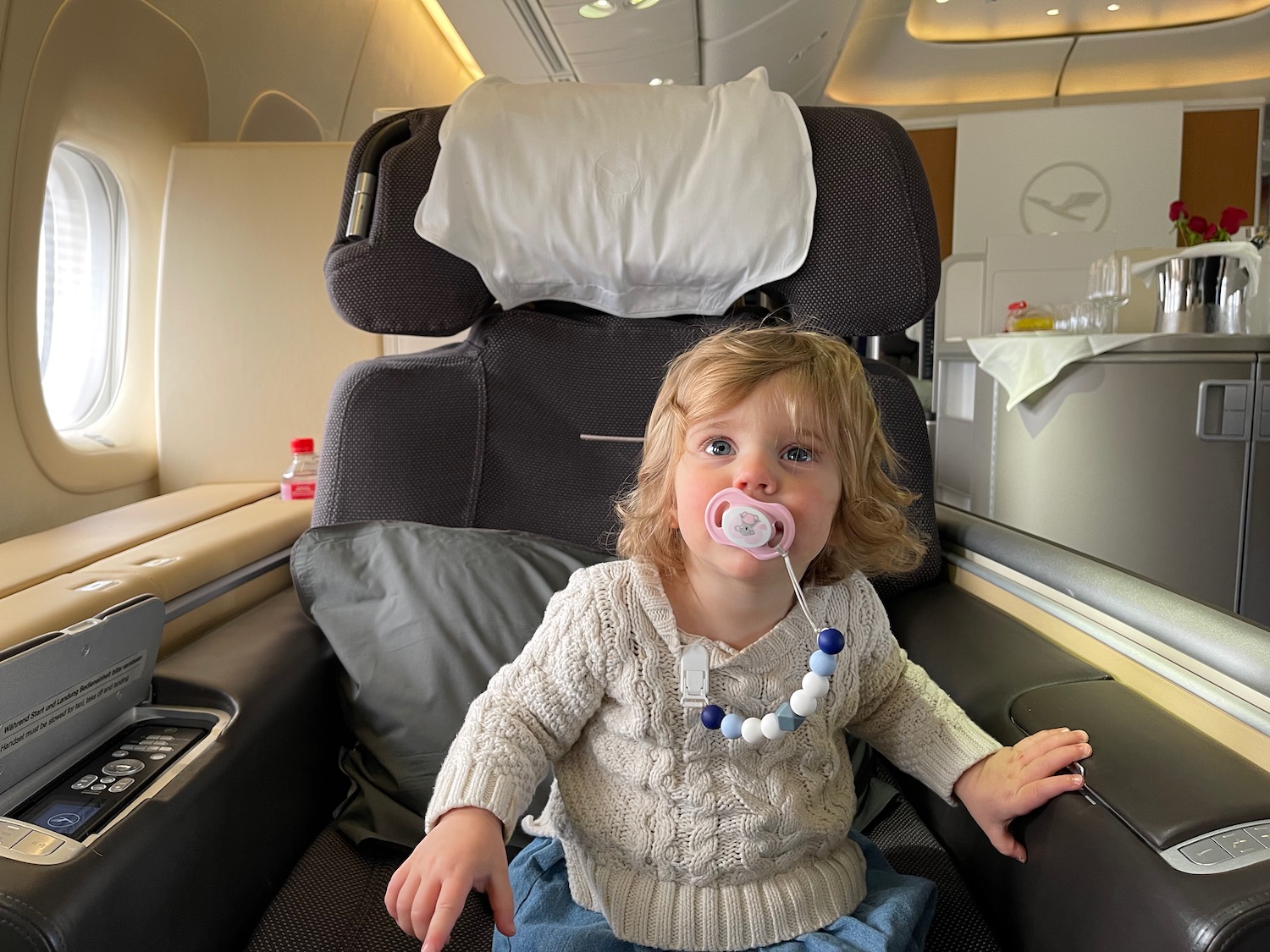 a child sitting in a chair with a pacifier in her mouth