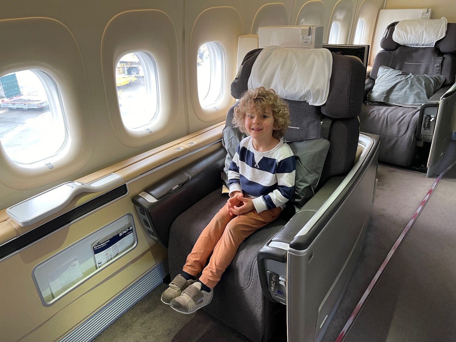 a child sitting in a chair in an airplane