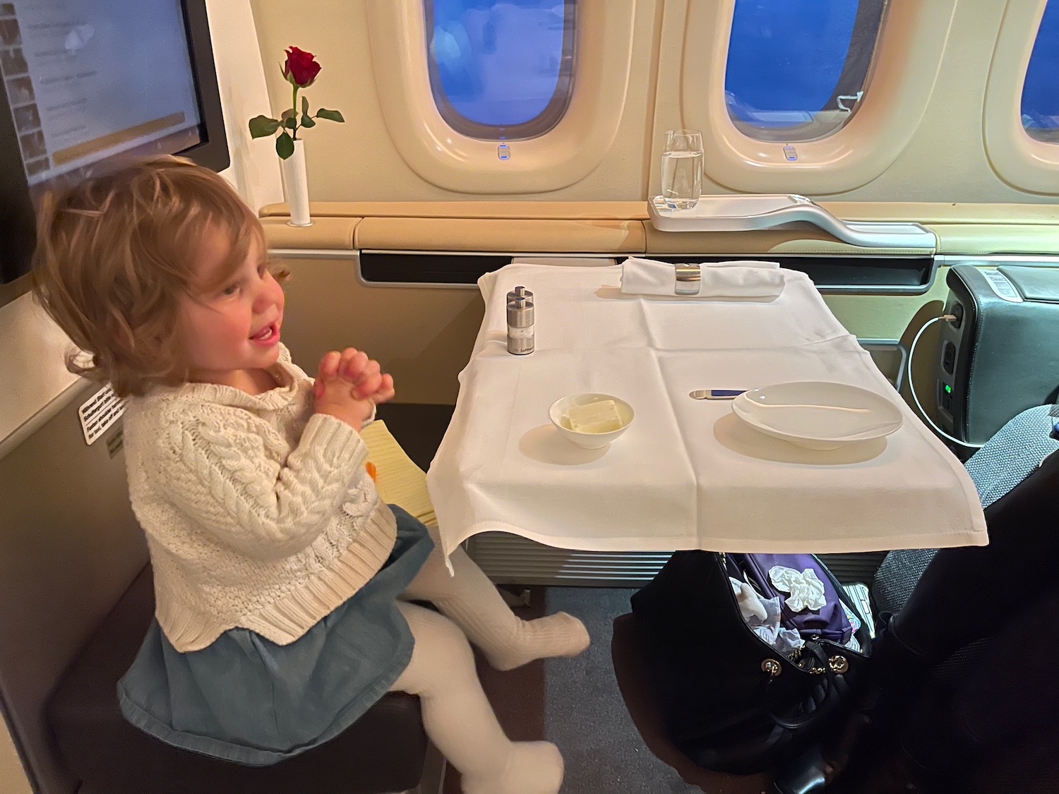 a child sitting at a table in an airplane