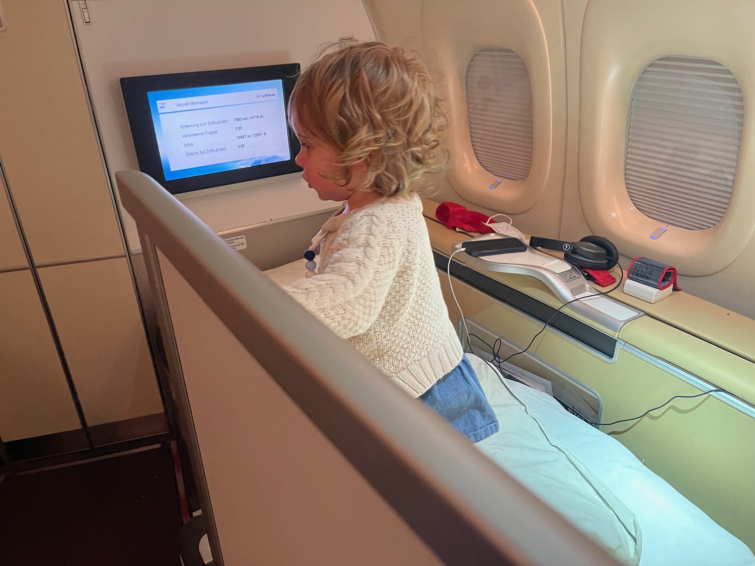 a child sitting on a bed in an airplane