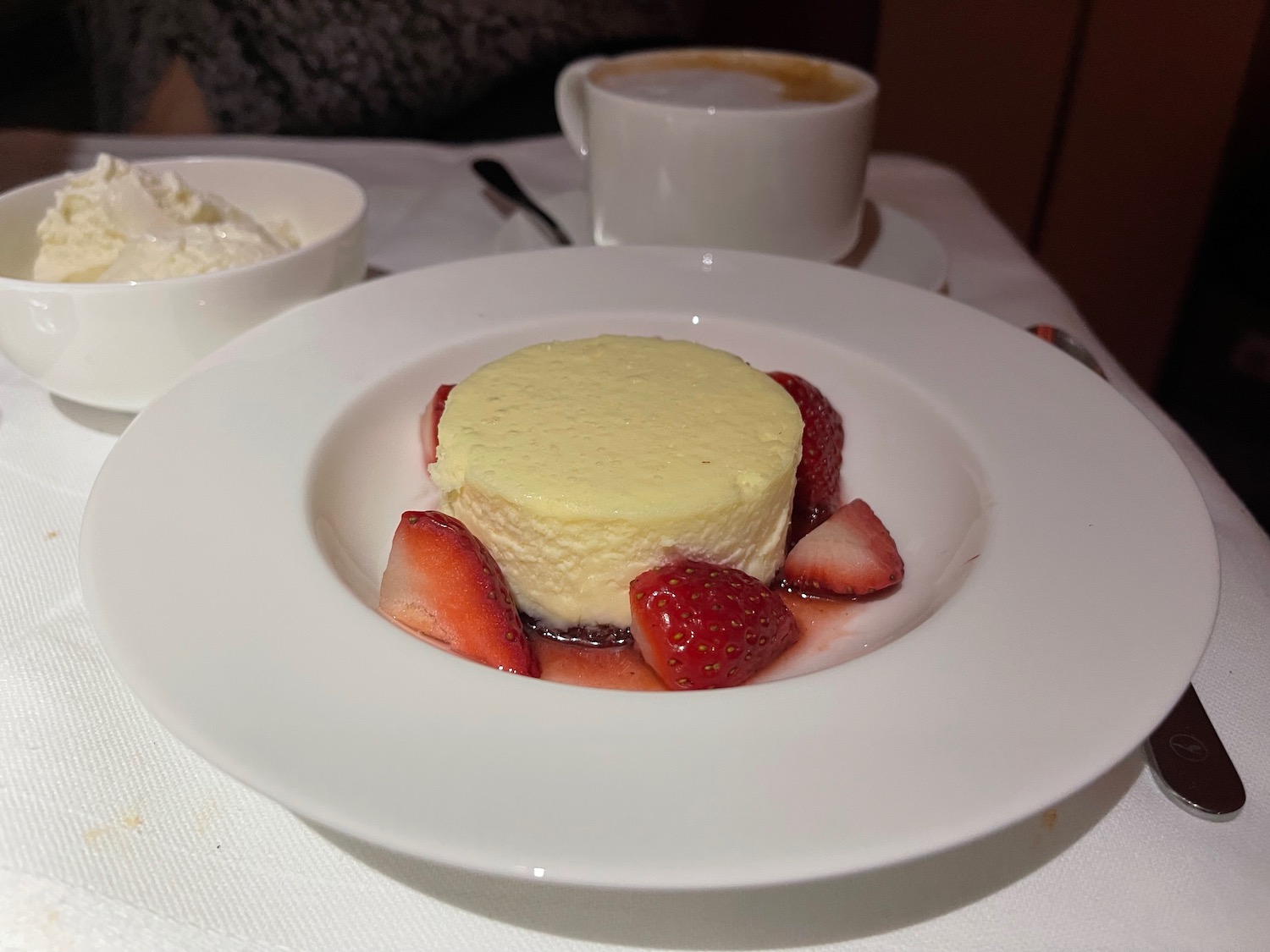 a plate of food with strawberries and a cup of coffee