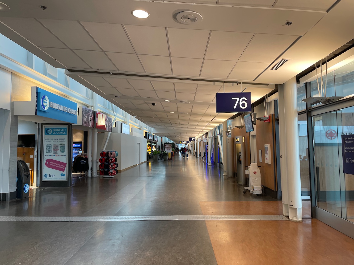 a large airport terminal with signs and people walking