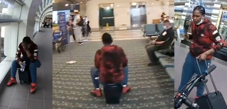 a man sitting on a suitcase in an airport