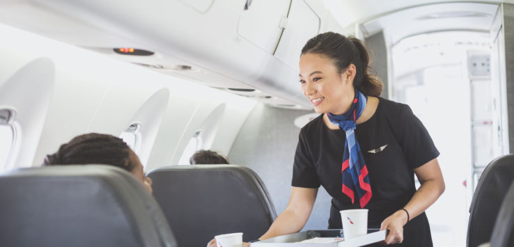 a woman serving a person on an airplane