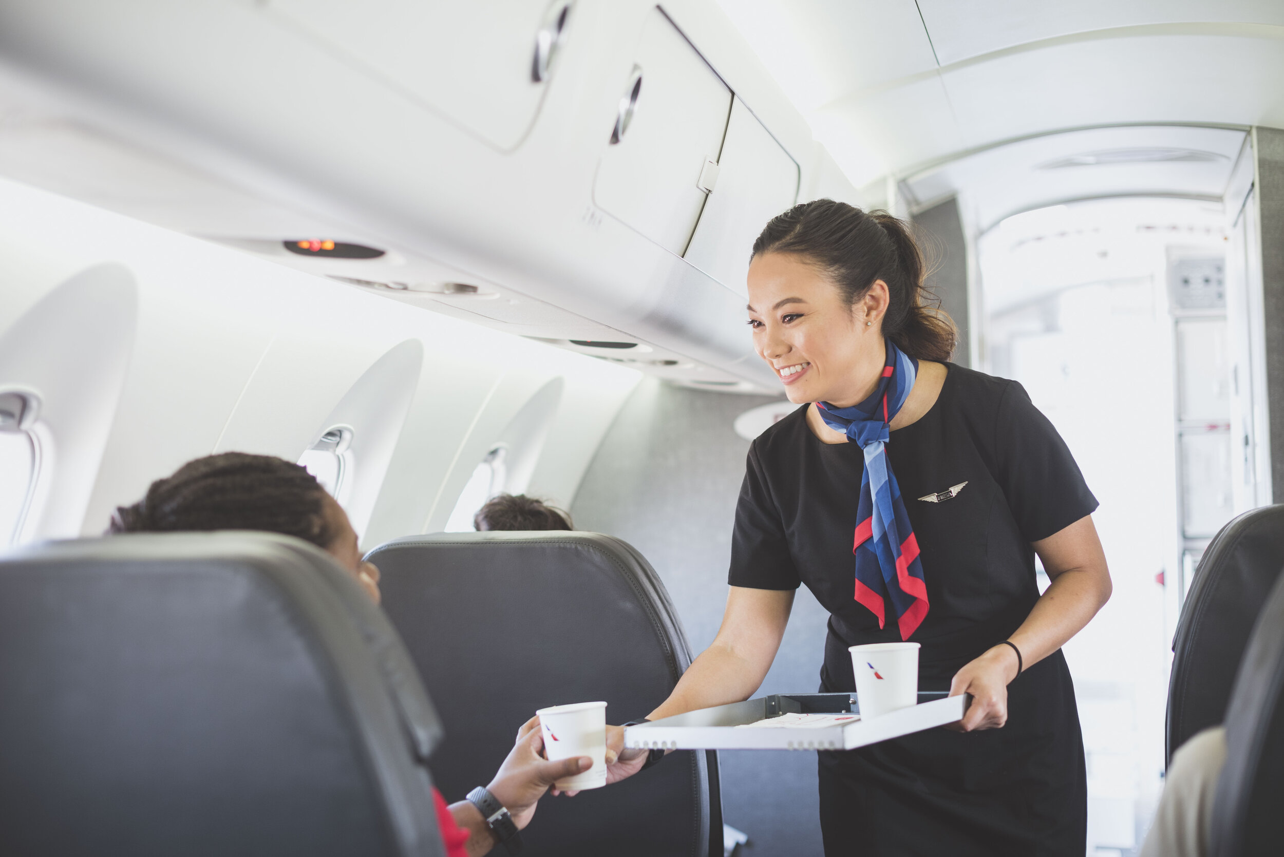 a woman serving a person on an airplane