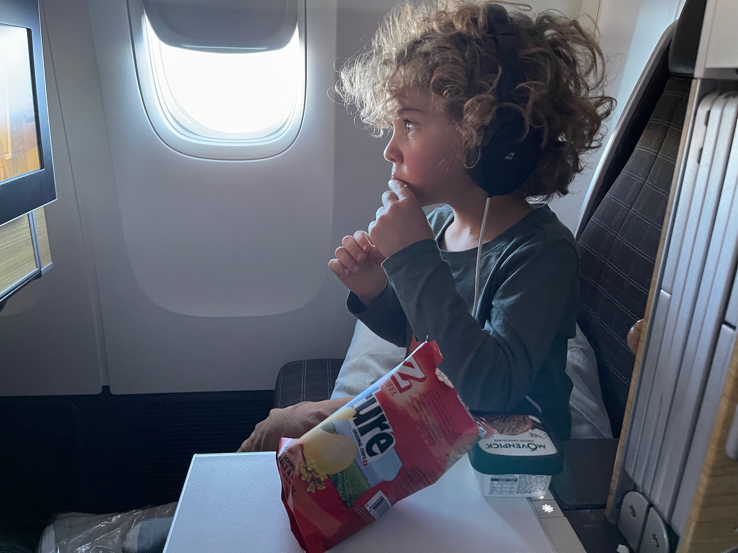 a child eating snacks on an airplane