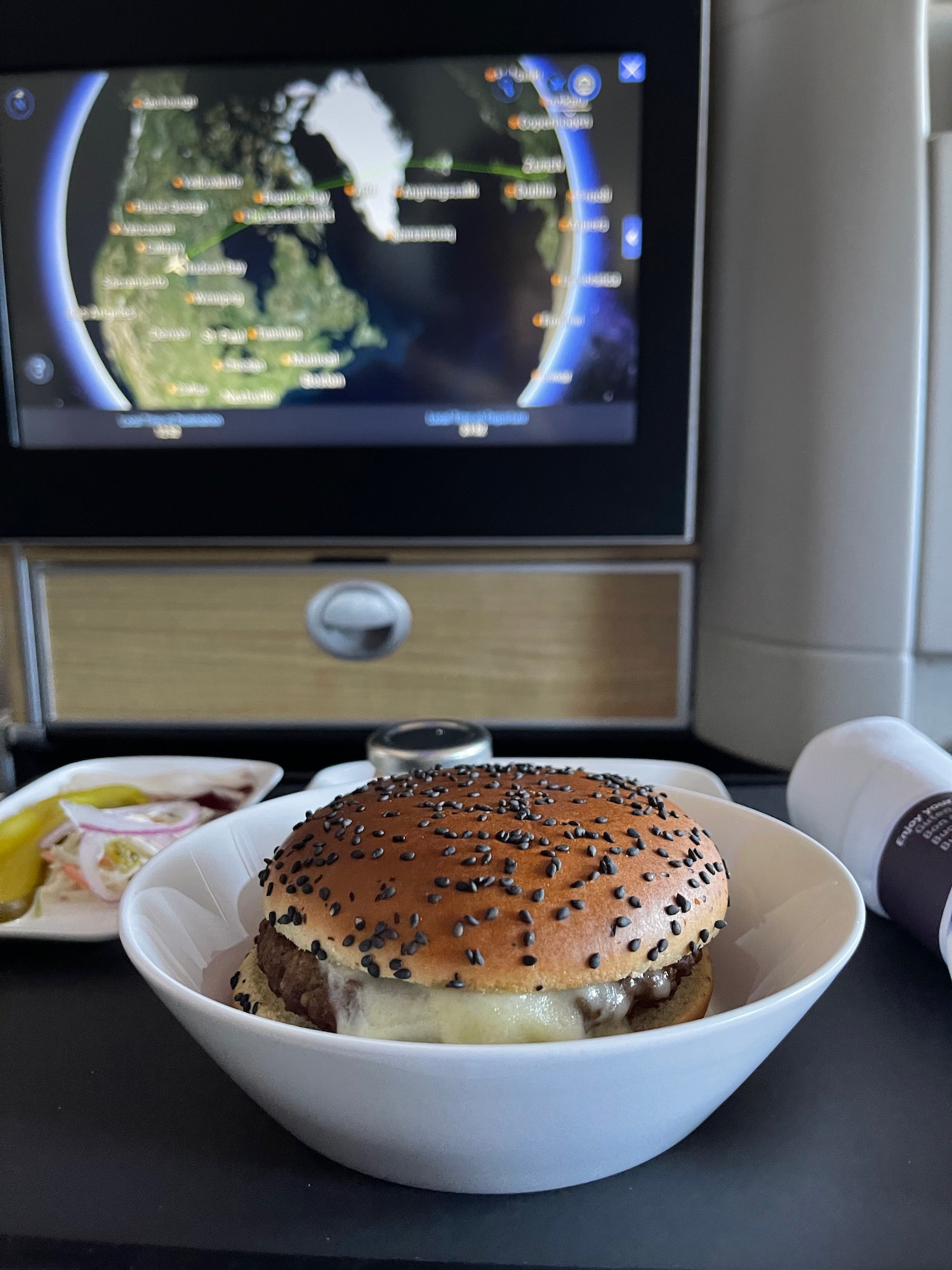 a burger in a bowl with a television in the background