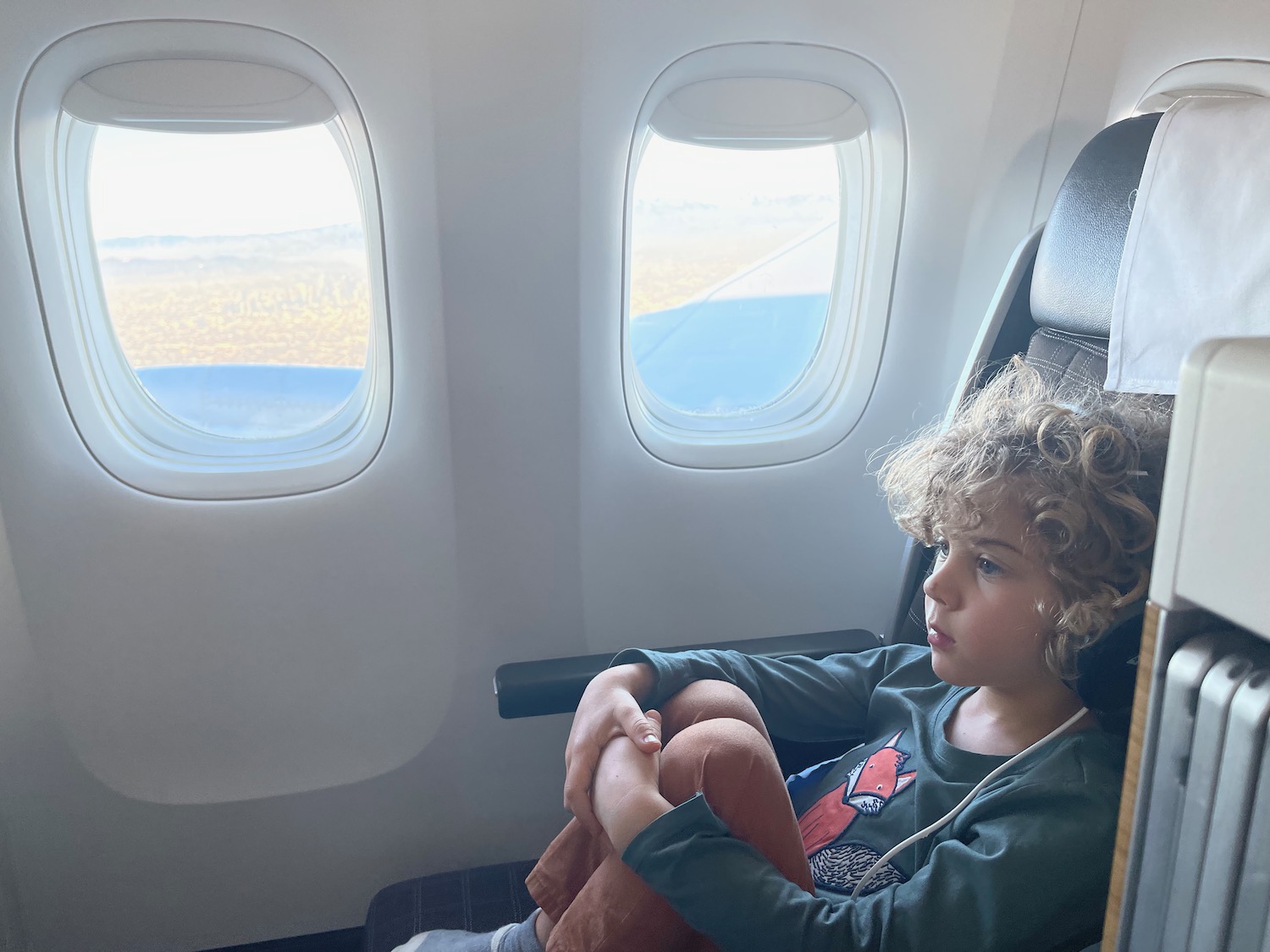 a child sitting in a chair with windows