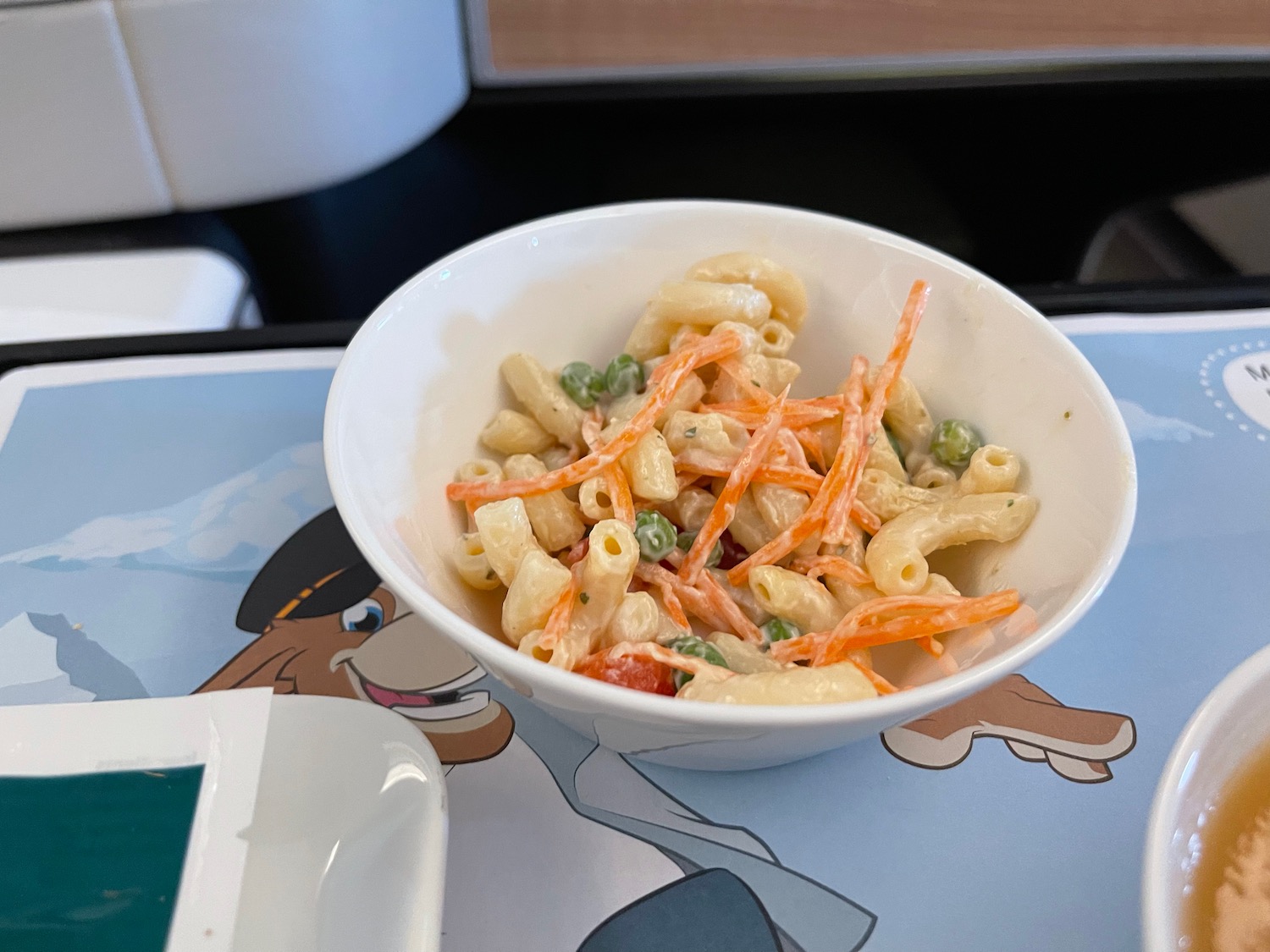 a bowl of pasta with carrots and peas