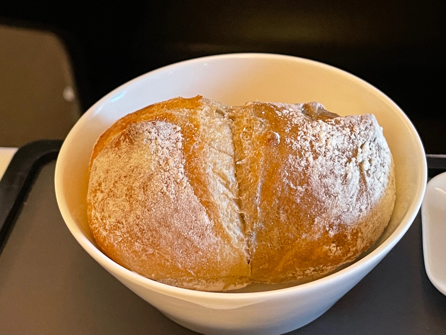 a white bowl with a loaf of bread