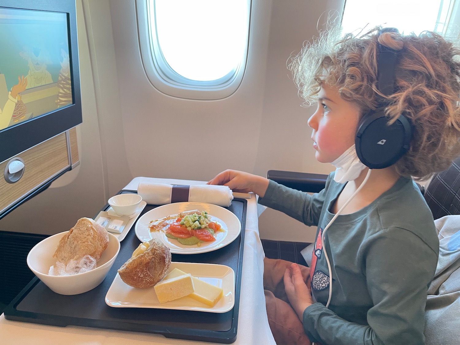 a child sitting in an airplane eating food