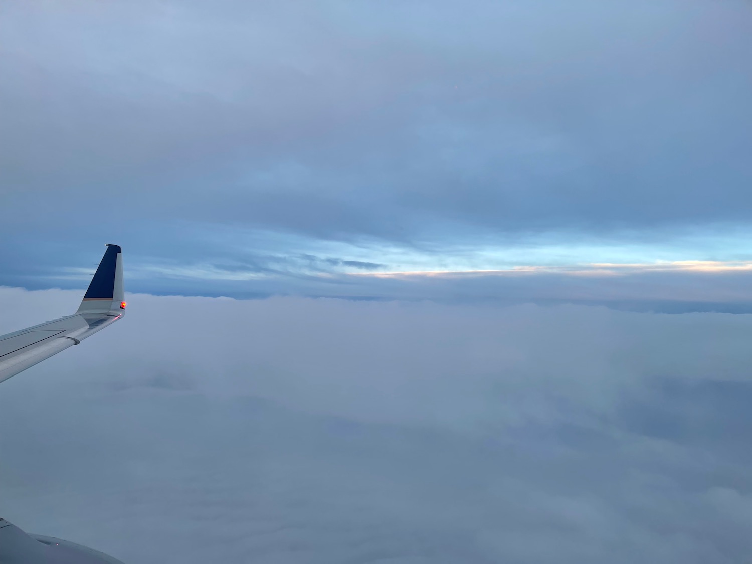 an airplane wing above the clouds