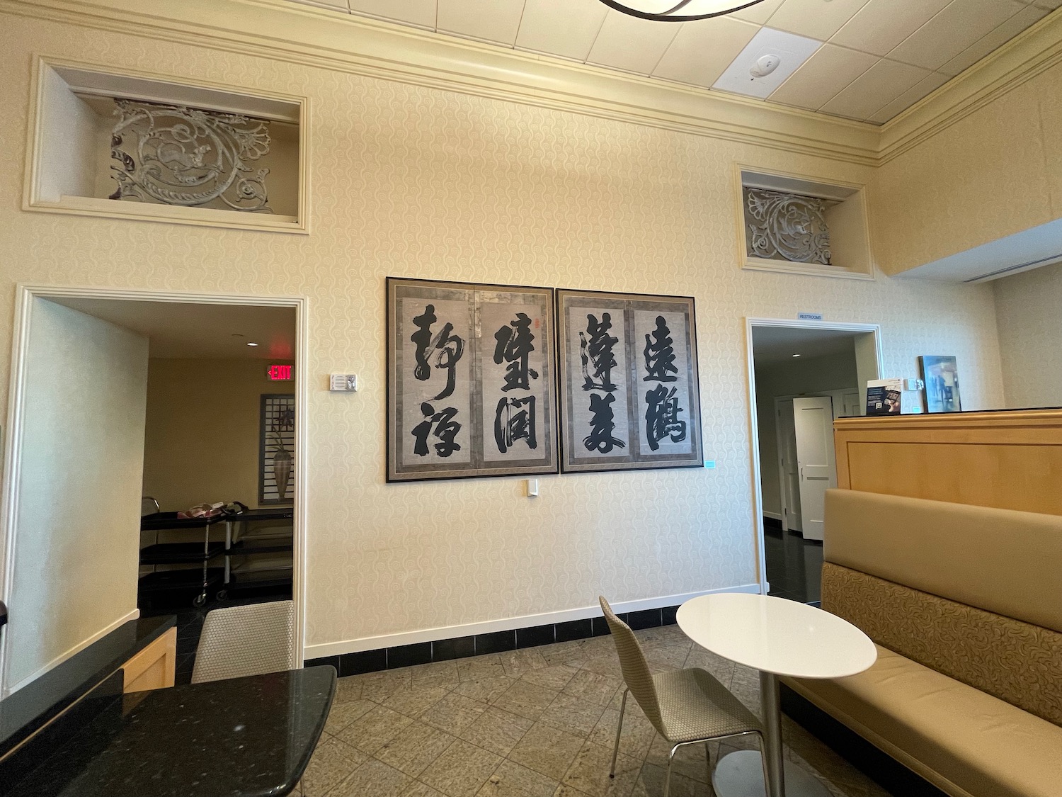 a room with a table and chairs and art on the wall