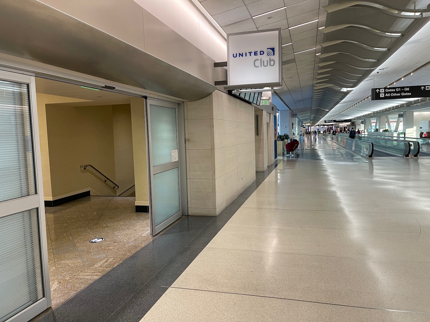 a hallway with a sign and people walking