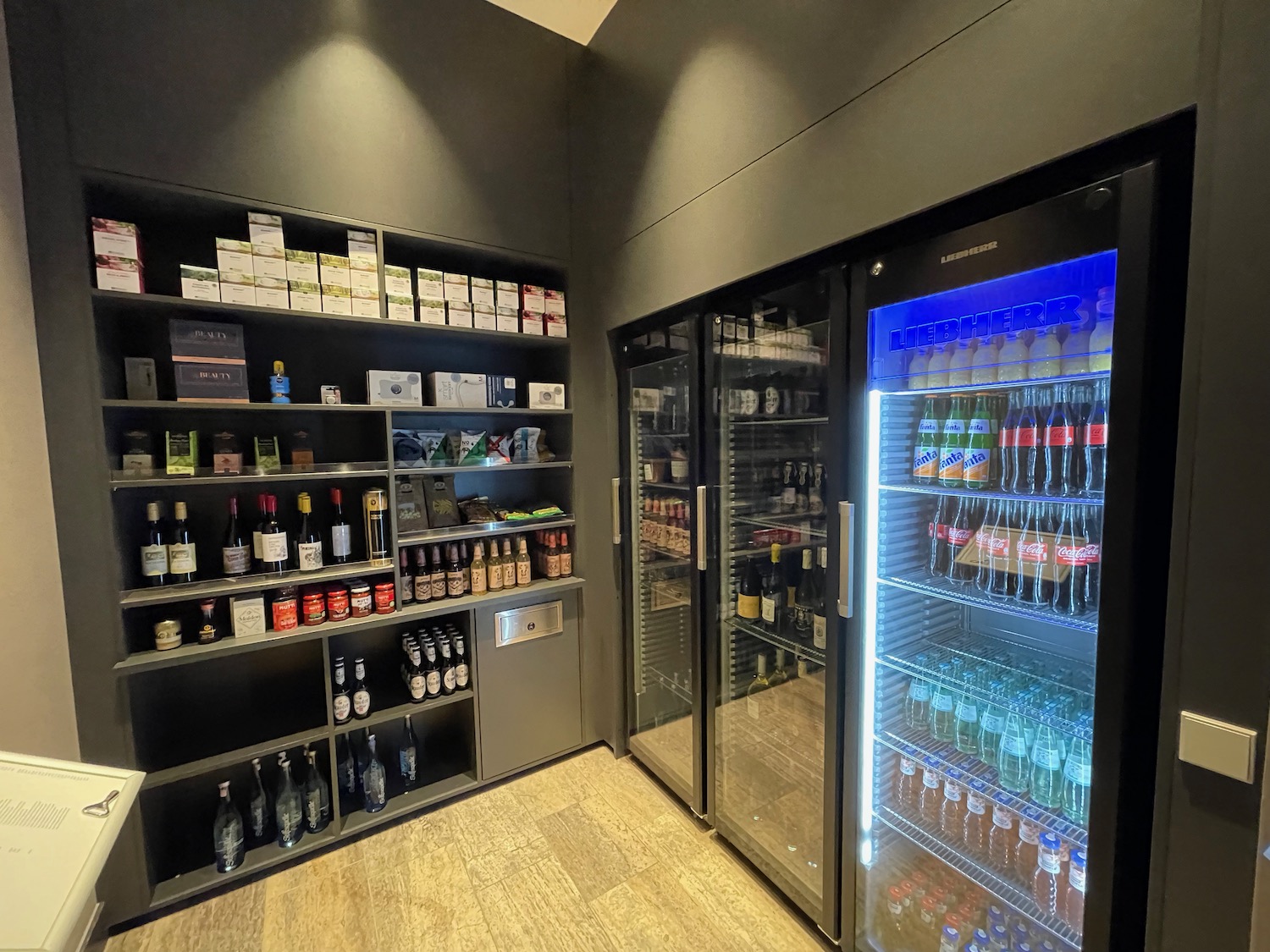 a room with shelves of beverages and a refrigerator