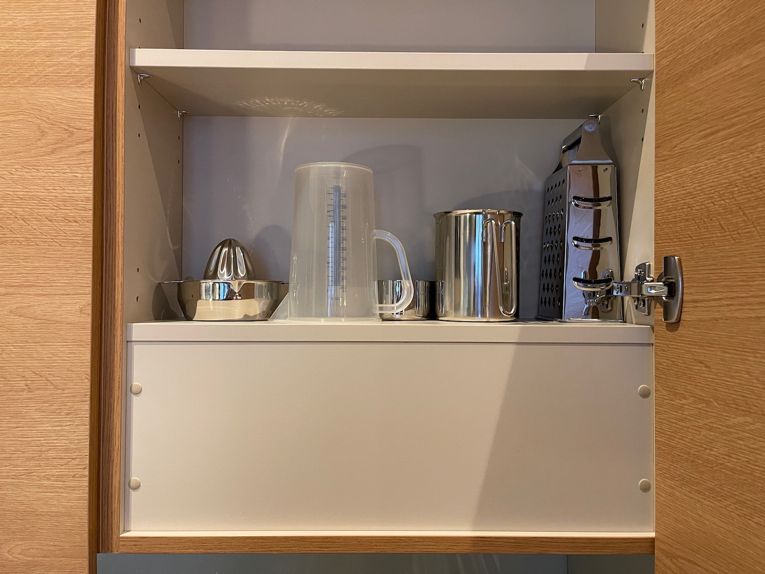 a shelf with a measuring cup and other objects on it